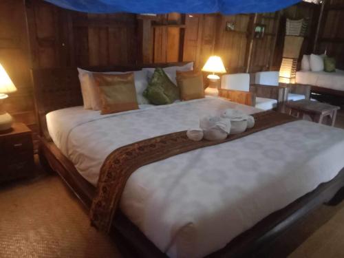 a bedroom with a large bed with two stuffed animals on it at On The Mekong Resort in Luang Prabang