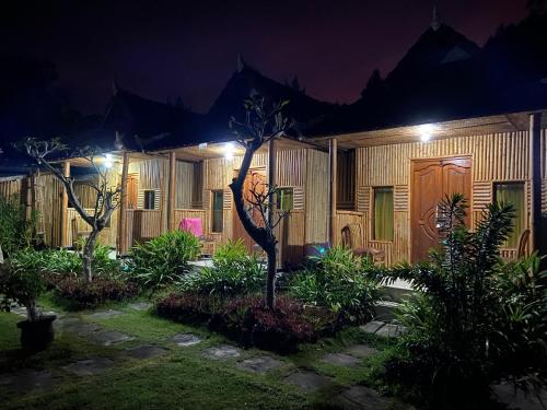 une maison éclairée la nuit dans l'établissement D'Yoga Bamboo Cabin, à Kintamani