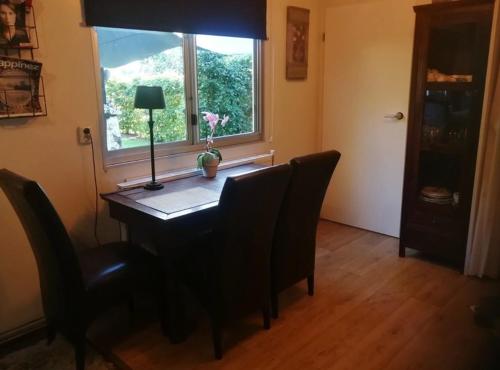 a room with a desk with chairs and a window at Het Huisje in Bergen op Zoom