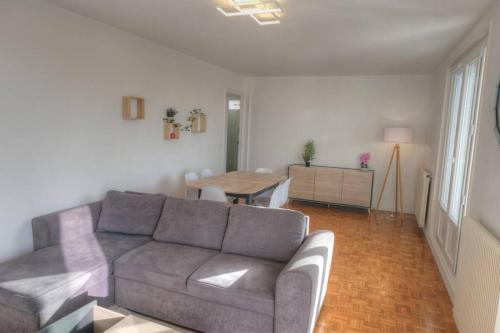 un salon avec un canapé et une table dans l'établissement Appartement 67m² 500m RER (20mn Paris) face Marne, à Champigny-sur-Marne