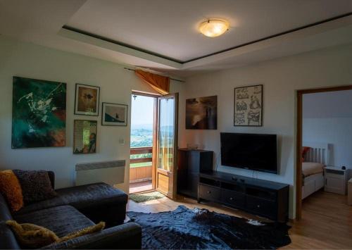 Il comprend un salon doté d'un canapé et d'une télévision à écran plat. dans l'établissement Le'Klet Holiday House, à Donji Kraj