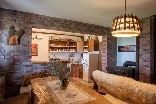 - un salon avec une table et un mur en briques dans l'établissement Le'Klet Holiday House, à Donji Kraj