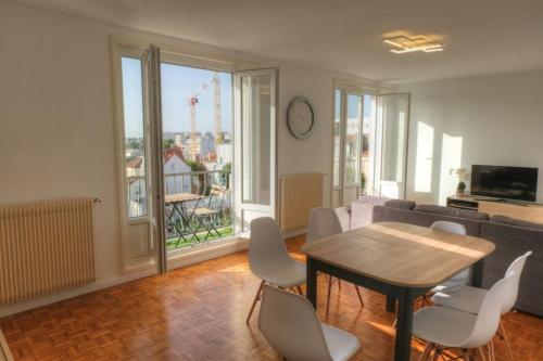 un salon avec une table, des chaises et un canapé dans l'établissement Appartement 67m² 500m RER (20mn Paris) face Marne, à Champigny-sur-Marne