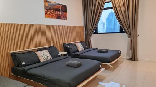 twee bedden in een kamer met een raam bij Chambers Suites KLCC by Moonlight in Kuala Lumpur
