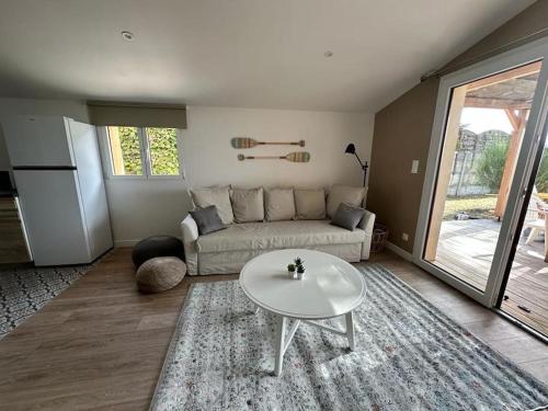 un salon avec un canapé et une table dans l'établissement Maison première ligne Tocade2, à Andernos-les-Bains