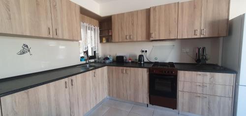 a kitchen with wooden cabinets and black counter tops at A day at Dee's in Birżebbuġa