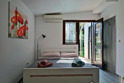 sypialnia z łóżkiem w pokoju z oknem w obiekcie JASNA house with apartment w mieście Umag