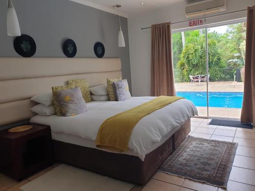 a bedroom with a bed and a swimming pool at Damicha Boutique Lodge in Ezulwini