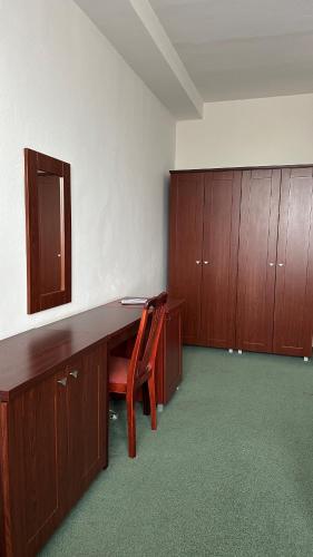 an empty office with a desk and wooden cabinets at Hotel Bothe in Považská Bystrica