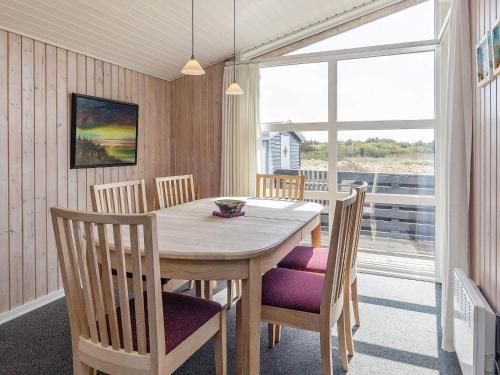 バイアス・スタンにある6 person holiday home in Vejers Strandのダイニングルーム(テーブル、椅子、窓付)