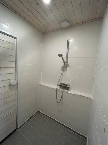 a bathroom with a shower in a white wall at Pieni omakotitalo joen rannalla in Rautio