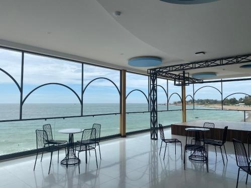 a room with tables and chairs and a view of the ocean at Khách sạn - Nhà hàng Hoàng Phúc in Tuy Phong