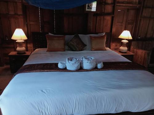 a bedroom with a large bed with two lamps at On The Mekong Resort in Luang Prabang