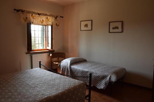 1 dormitorio con 2 camas y ventana en Da Poldino, en Borgo a Buggiano