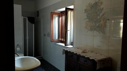 a bathroom with a sink and a toilet and a window at Da Poldino in Borgo a Buggiano