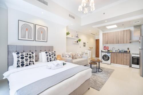 a bedroom with a large bed and a kitchen at Heaven Crest Holiday Homes Downtown - Studio, 1 & 2 Bedroom Suites beside Dubai Mall and Burj Khalifa in Dubai