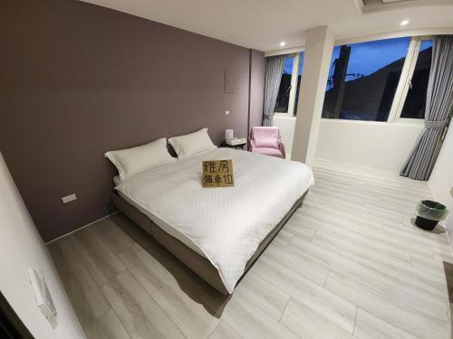 a bedroom with a large bed and a pink chair at Slowly B&B in Jiufen