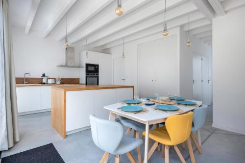 une salle à manger avec une table et des chaises dans une cuisine dans l'établissement Séjour apaisant pour 6 au Pouliguen, au Pouliguen