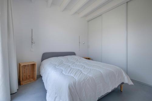une chambre avec un lit blanc et une armoire en bois dans l'établissement Séjour apaisant pour 6 au Pouliguen, au Pouliguen
