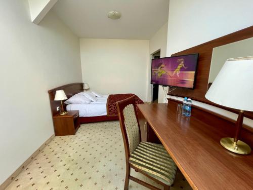 a hotel room with a desk and a bed at Gościniec Uniejów in Uniejow