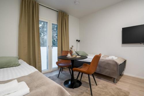 a hotel room with a bed and a table and a window at Studio Haarajoki in Järvenpää