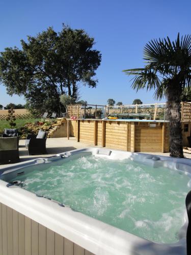 a jacuzzi tub on the back of a house at Gîte avec vue imprenable in Fougerolles