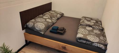 uma pequena cama com duas almofadas em cima em Apartmán 604 em Vrbno pod Pradedem