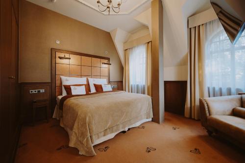 a bedroom with a bed and a couch and a window at Grape Hotel in Wrocław