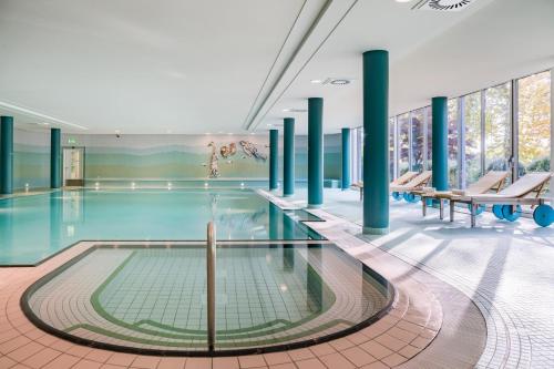 a swimming pool with blue columns in a building at Seehotel Rheinsberg in Rheinsberg