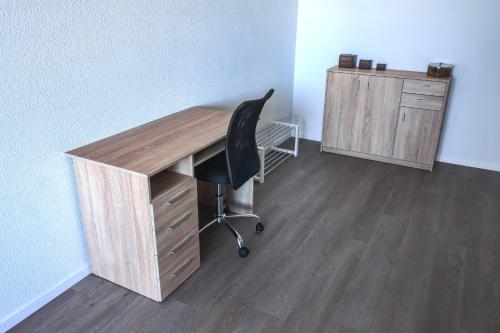 an office with a desk and a chair and a cabinet at Pit Stop Apartments in Cham