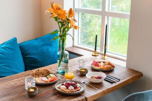 Hótel Goðafoss Fosshóll في Godafoss: طاولة مع طعام الإفطار و مزهرية مع الزهور