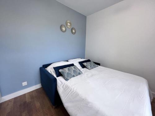 Ce lit se trouve dans une chambre dotée d'un mur bleu. dans l'établissement 2P Studio Boulogne Parc des Princes, à Boulogne-Billancourt