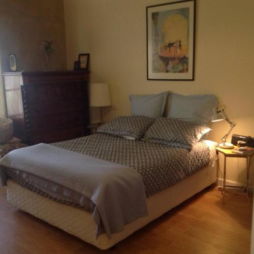 a bedroom with a bed and a lamp on a wooden floor at Strawbale House Bacchus Marsh in Bacchus Marsh