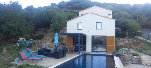 una casa con piscina frente a una casa en Maison neuve Vue imprenable Piscine et spa, en Calenzana