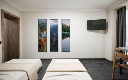 a hotel room with four paintings on the wall at Drevny Grad Park-hotel in Lviv
