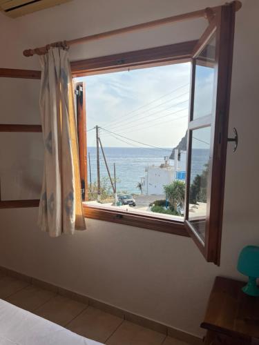 a window in a room with a view of the ocean at Panorama Zimmer und Apartments Lentas in Léntas