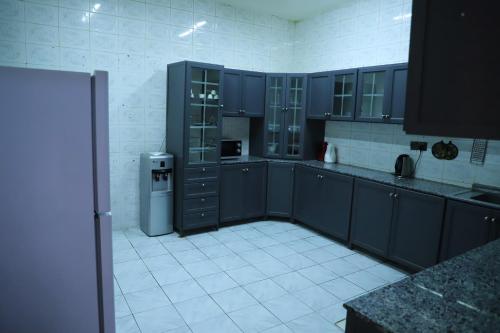 a kitchen with blue cabinets and a white tile floor at Durat Al Urubah in Riyadh