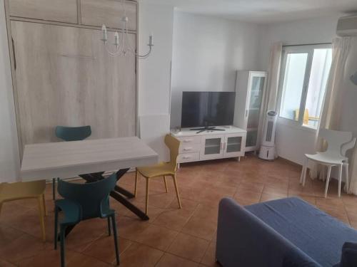 a living room with a tv and a couch and chairs at Apartamento Cerca de la Playa in Almería