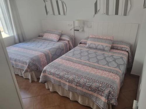 Zimmer mit 3 Betten mit Decken und Kissen in der Unterkunft Apartamento cerca de la playa in Almería