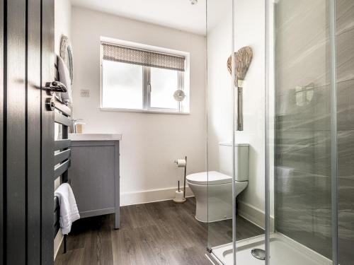 a bathroom with a toilet and a glass shower at Modern and comfortable home near the river with parking in Exeter
