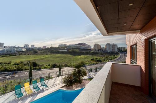 a balcony with a swimming pool and a view of a city at Elegant villa w dual pools in Carnaxide in Carnaxide