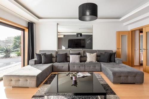 sala de estar con sofá y mesa en ALTIDO Elegant villa with dual pools in Carnaxide, en Carnaxide