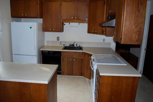 a kitchen with wooden cabinets and a white refrigerator at Northend Tacoma Charmer in Tacoma