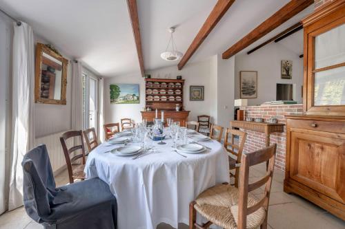une salle à manger avec une table et des chaises blanches dans l'établissement 300m de la plage - Les Trois Sources, à Préfailles