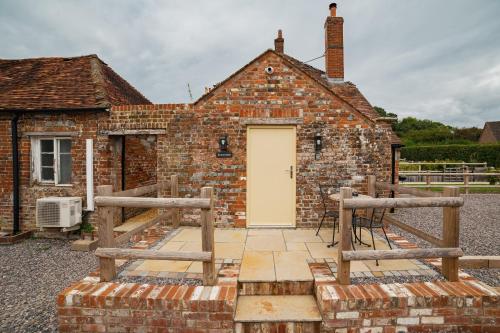 an old brick building with a white door at The Barrel Room at The Northbrook Arms in Winchester