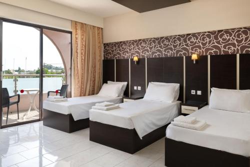 a hotel room with two beds and a balcony at Rose Hotel Faliraki in Faliraki