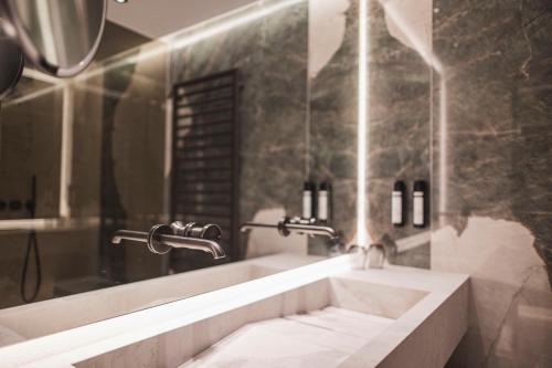 a bathroom with a sink and a bath tub at Hotel Lanerhof active/spa/balance in San Lorenzo di Sebato