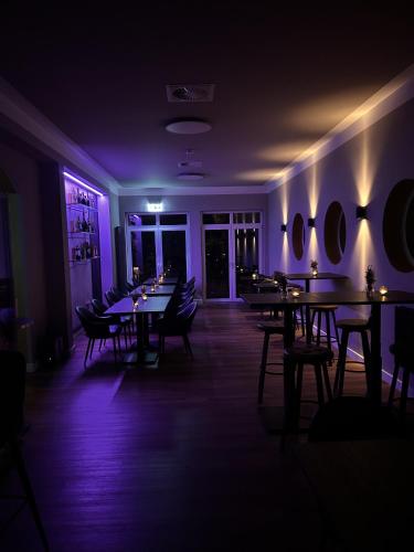a restaurant with tables and chairs in a dark room at Pension und Location Cham in Meerbusch