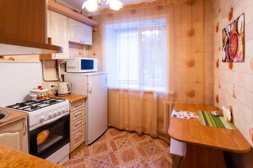 a small kitchen with a stove and a refrigerator at Киев in Petropavlovsk