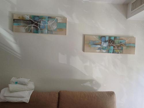two pieces of art hanging on a wall at Lyrioshomes Apartamento Filpo Rojas , Sevilla in Seville